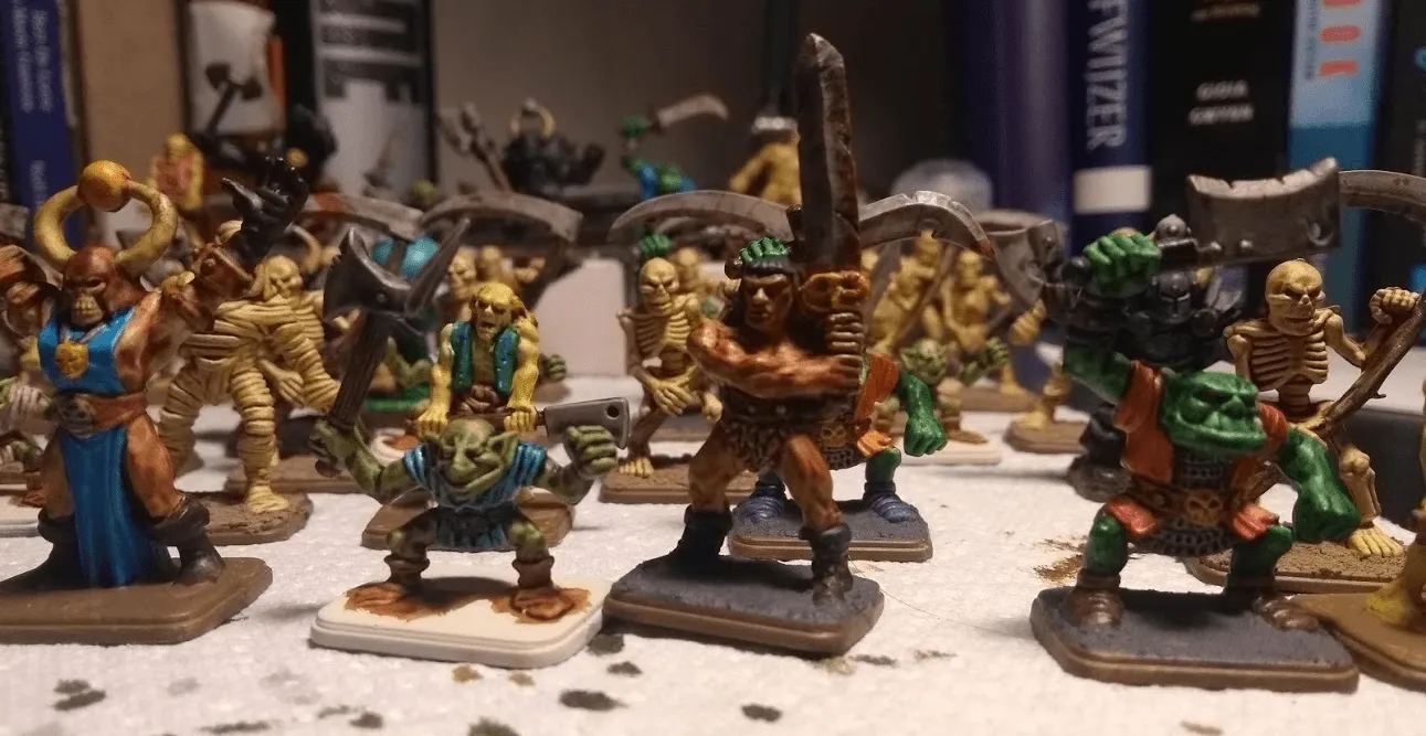 Painted HeroQuest miniatures: a barbarian, orcs, a goblin, skeletons and mummies