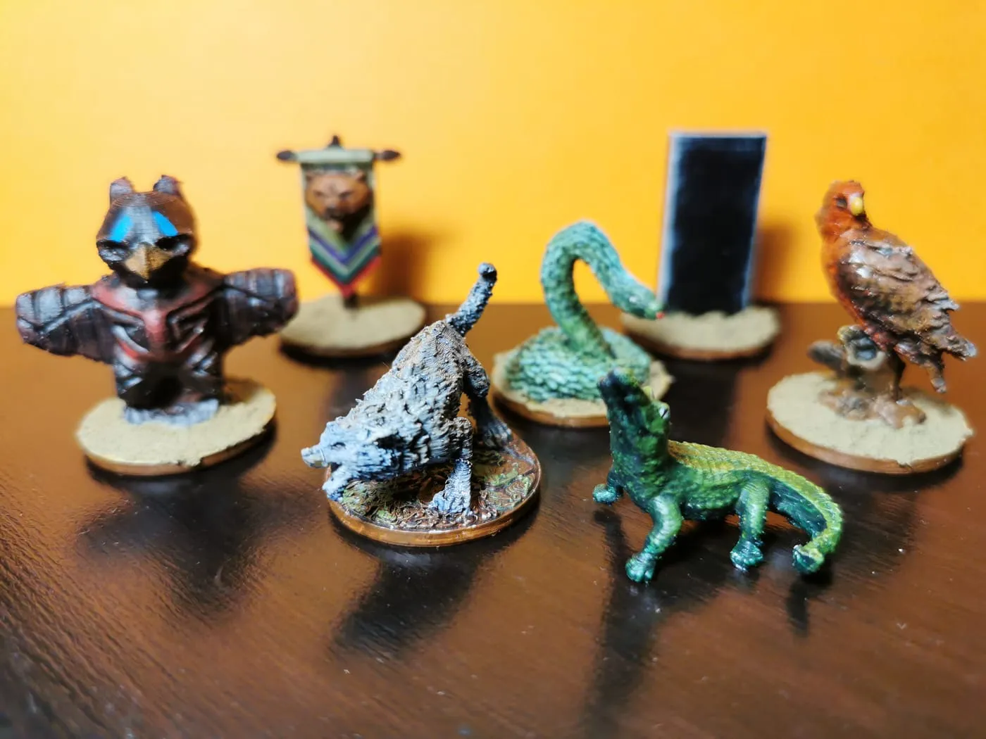 Painted summon minis: a bird warrior, a wolf, a snake, a crocodile, a hawk and a banner
