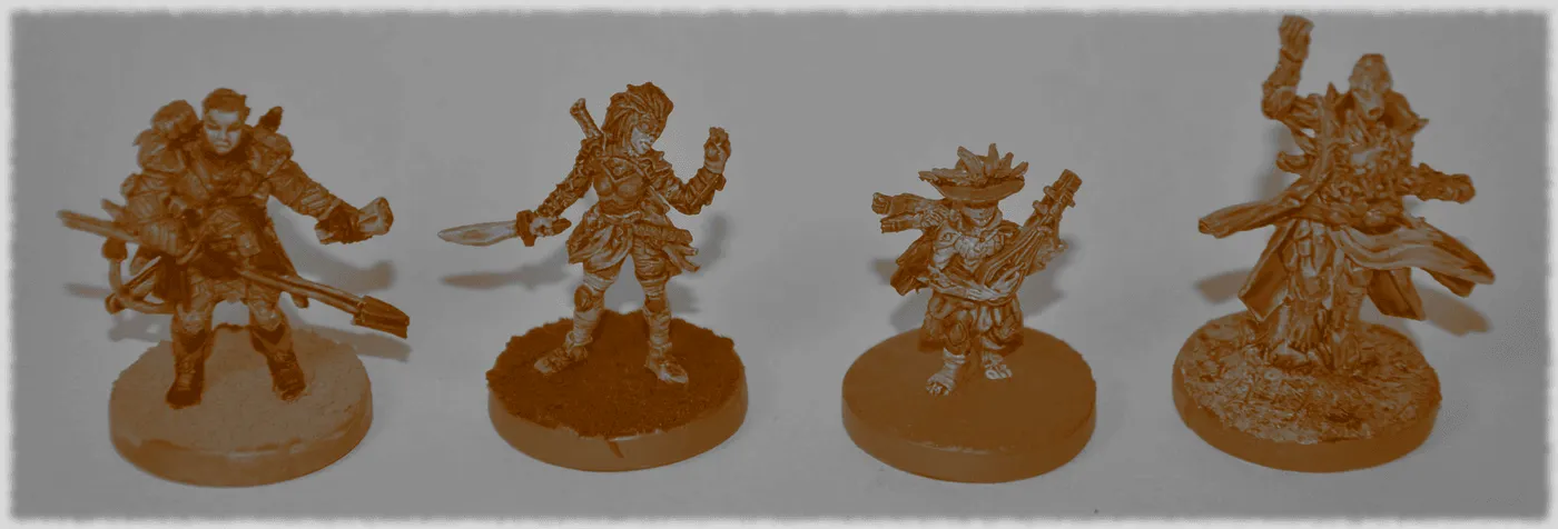 Four Gloomhaven hero miniatures on round bases, in a sepia-toned photo